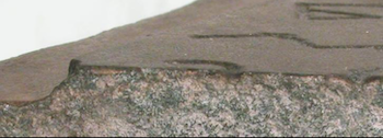 Figure 3. Enlargement of Figure 2. Note the broken part of the lower part of the "lamed" and the lower part of the "kuf." The thin patina composed of biogenic iron oxide is attached firmly to the rock surface and covers the grooves of the letters (the black and brown-patina is 1 mm thick).