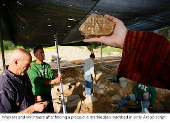 Workers and volunteers after finding a piece of a marble slab inscribed in early Arabic script.